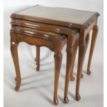 A Nest of Three Walnut Tables with Glass Inset Tops, 55cm wide