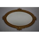 A Carved Gilt Wood Oval Wall Mirror Decorated with Roses and Leaves, 92 x 69cms
