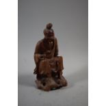 A Carved Figure of Seated Tradesman with Paper Label for Hong Kong, 15cm high