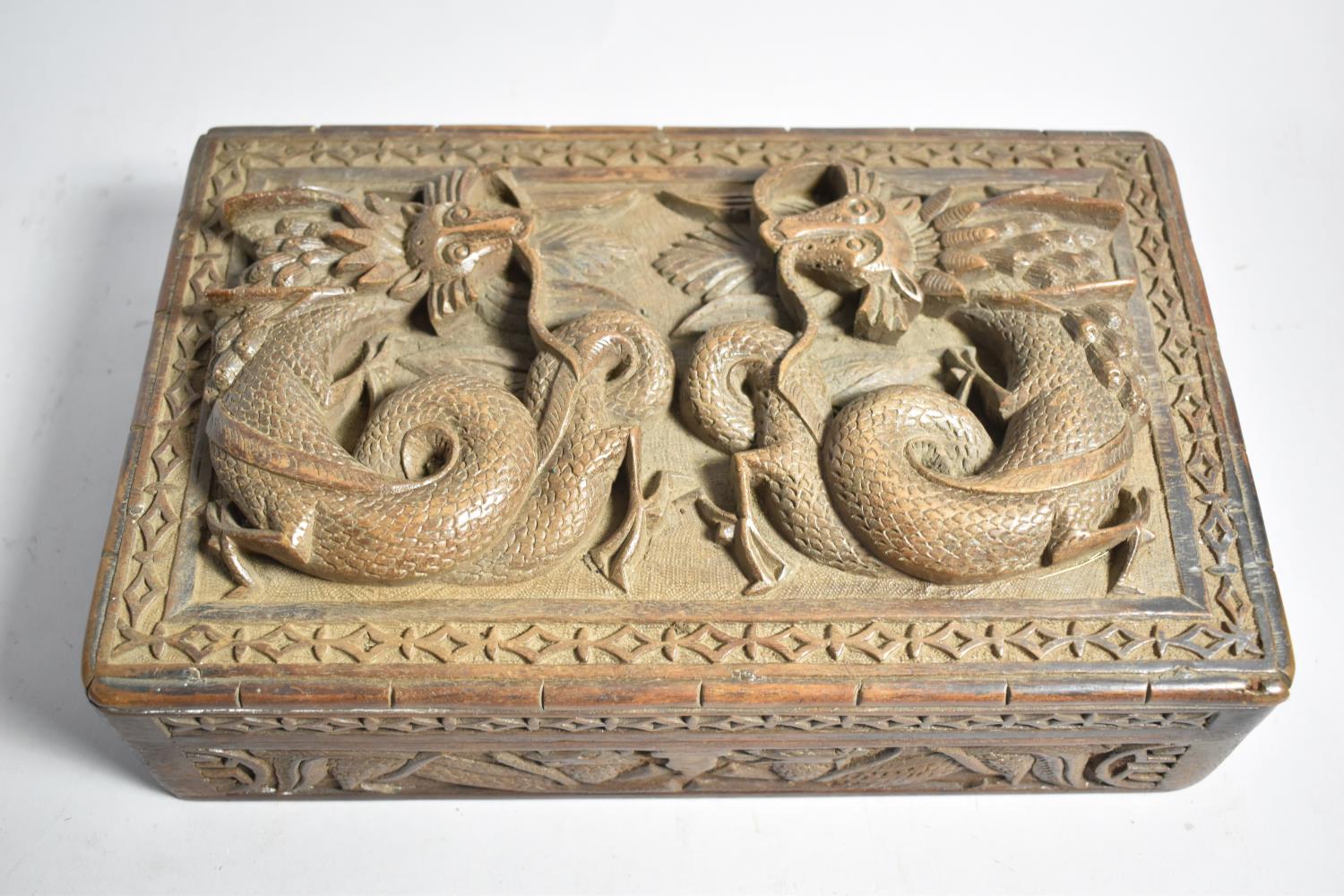 A Chinese Carved Wooden Box, the Hinged Lid Decorated with Two Dragons, Three Section Interior, 27.