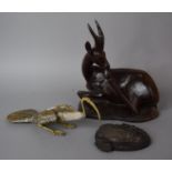 A Carved African Study of a Reclining Antelope, Together with a Metal Study of a Bird and a Resin