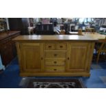 A Modern Light Oak Sideboard with Two Small and Three Long Centre Drawers Flanked by Cupboards,