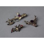 An Amethyst and Garnet Stag Head Silver Brooch, Scottish Axe and Thistle White Metal Brooch and a