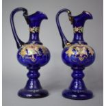 A Pair of Cobalt Blue Claret Jugs with Enamelled Floral Decoration, 21cm high