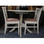 A Modern Circular Cream Painted Kitchen Table and Two Spindle Back Chairs