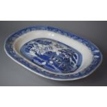 A Large Blue and White Willow Pattern Draining Dish