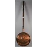 A Copper Bed Warming Pan with Turned Wooden Handle