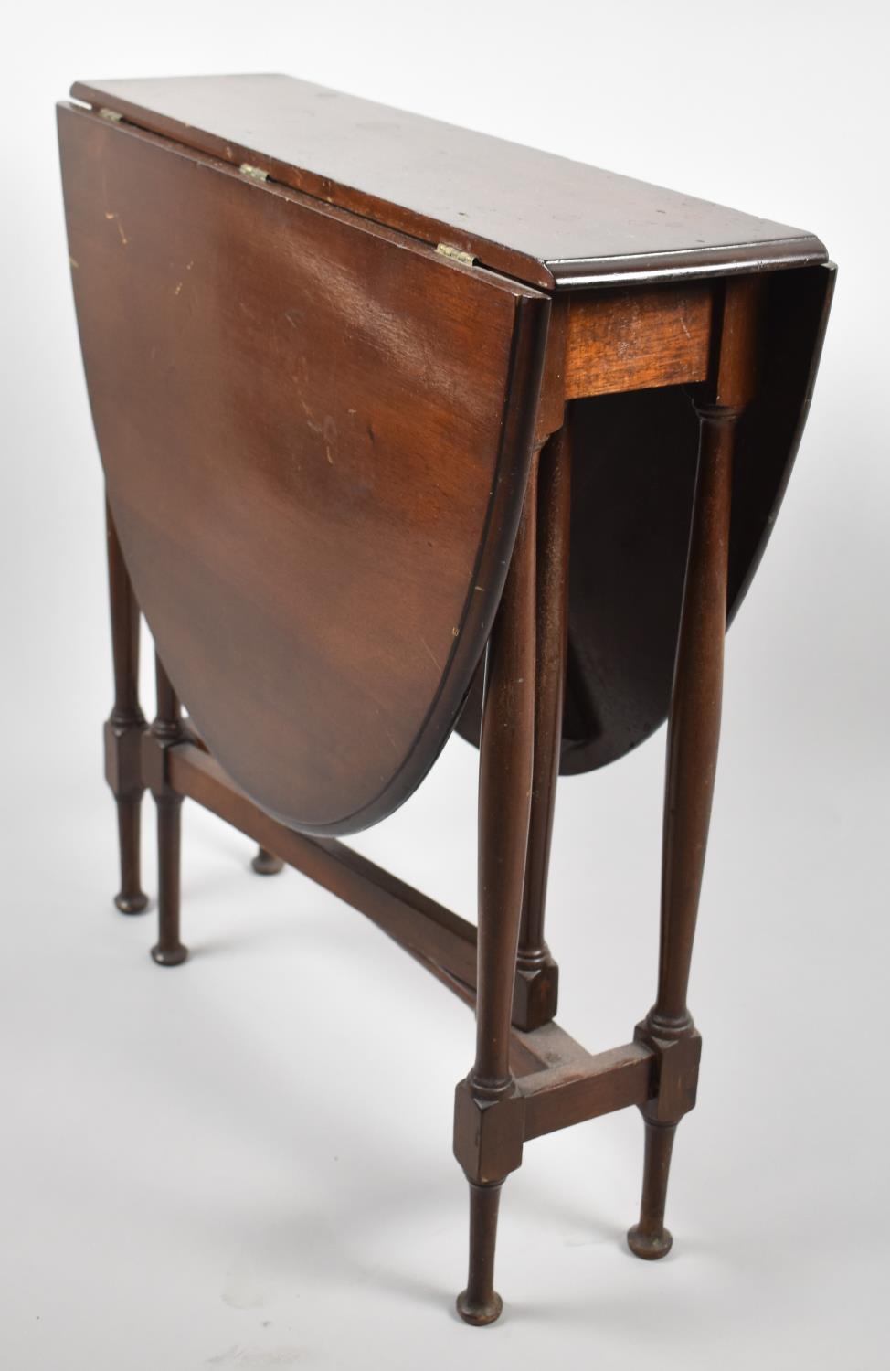 An Edwardian Mahogany Oval Top Drop Leaf Sutherland Table on Turned Supports, 60cm Long