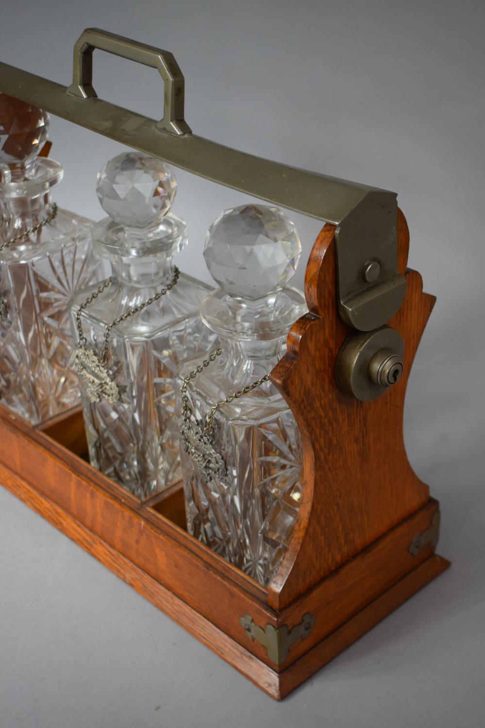 A Modern Three Bottle Oak and Silver Plated Tantalus with Decanter Labels for Whisky, Brandy and - Image 2 of 2