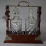 A Reproduction Silver Plate Mounted Two Bottle Tantalus with Whisky and Brandy Decanter Labels