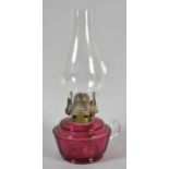 An Edwardian Cranberry Glass Oil Lamp with Plain Glass Chimney, Total Height 29cm