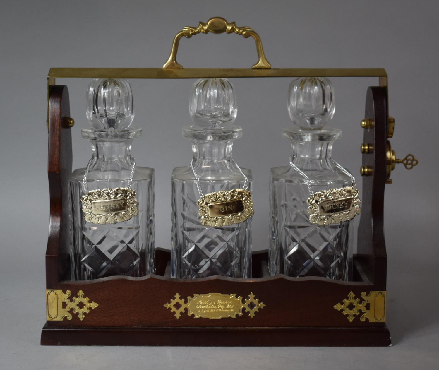 A Modern Brass Mounted Three Bottle Tantalus with Decanter Labels for Sherry, Gin and Whisky,