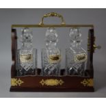 A Modern Brass Mounted Three Bottle Tantalus with Decanter Labels for Sherry, Gin and Whisky,