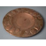 An Arts and Crafts Pressed Copper Wall Charger, the Border Decorated with Fruit, 26cm diameter