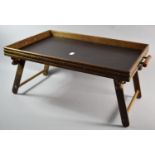An Edwardian Bed Tray with Folding Legs and Two Turned Handles, 56cm wide, Base Needs Small Repair