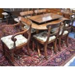 A Crossbanded Oval Extending Mahogany Dining Table with Two Extra Leaves and Brass Casters to
