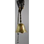 A Novelty Wall Hanging Brass Bell Supported on Ebonised Elephants Head