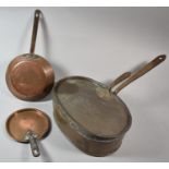 A Lidded Oval Copper Saucepan with Iron Handles, Together with Two Copper Skillets, One Inscribed