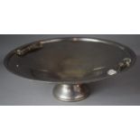 A Metal Footed Bowl with Stylised Tassel Handles, 42cms Diameter