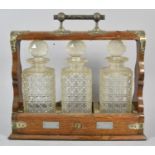 An Edwardian Oak and Silver Plate Mounted Three Bottle Tantalus with Key, 37cm wide