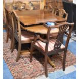 A Mahogany Twin Pedestal Extending Dining Table with Two Leaves Together with Six Regency Striped