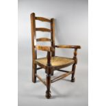 An Oak Framed Rush Seated Child's Leather Back Arm Chair