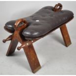 A Mid 20th Century Leather Upholstered Camel Saddle Stool, 78cm wide