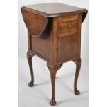 An Edwardian Mahogany Oval Topped Drop Leaf Work Table with Single Drawer Over Cupboard Base,