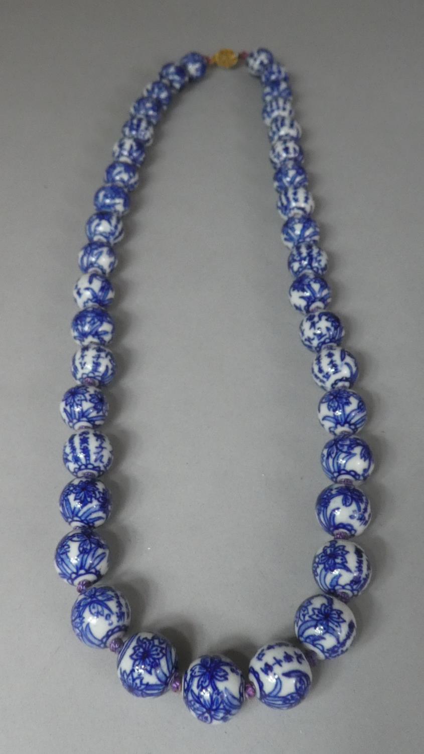 A String of Chinese Porcelain Beads with Characters and Flower Decoration Having Gilt Filigree