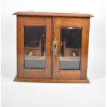 An Edwardian Oak Smokers Companion with Glazed Doors to Fitted Interior Having Two Small Drawers and