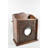 An Edwardian Oak Galleried Wall Mounting Cabinet with Carved Door Having Mirror Inset
