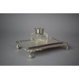 A Mappin and Webb Silver Inkstand on Four Scrolled Feet with Silver Topped Glass Ink Bottle,