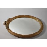 A Gilt Framed Oval Wall Mirror with Swag and Bow Finial, 44cm high