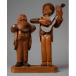 A Carved Wooden Black Forest Novelty Corkscrew and Bottle Opener Set in the Form of Gent Singing and