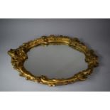 An Ornate Gilt Plaster Framed Oval Mirror, 66cm high