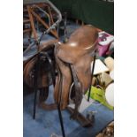 A Leather Saddle and Metal Stand