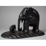 A Carved African Ebonised Study of Elephant and Calf on Oval Plinth Base, 23.5cm Long