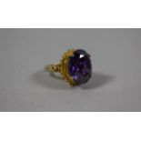 A Gilt White Metal Ladies Dress Ring Having Large Purple Stone and CZ Mounts, Size M