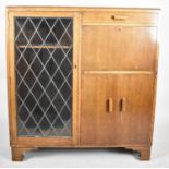 A Mid 20th Century Oak Lead Glazed Cabinet with Top Cutlery Drawer over Fall Front Bureau and Base