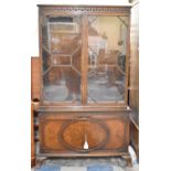 A Mid 20th Century Walnut Astragal Glazed Bookcase with Carved Top Rail Having Dentil and Rosette