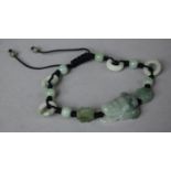 A Souvenir Jade and Cord Bracelet with Laughing Buddha Mount