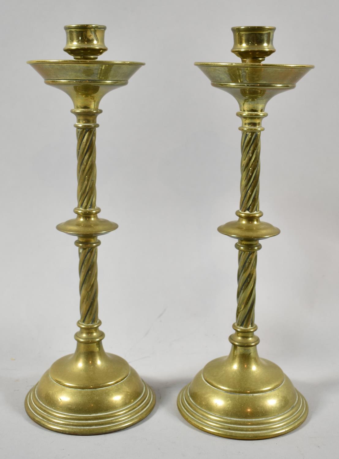 A Pair of Arts and Crafts Brass Candlesticks with Twisted Stems, 26.5cm high