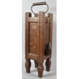 An Arts and Crafts Oak Fire Tidy Set with Brass Carrying Handle and Tools, 55cm high