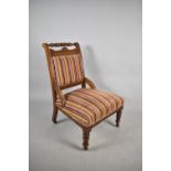 An Edwardian Walnut Framed Ladies Nursing Chair with Striped Velvet Upholstery