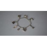 A Vintage Silver Charm Bracelet with Seven Silver and White Metal Charms