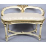 A Cream and Gilt Oval Window Seat with X Stretcher on Turned Reed Supports and Raised Back with Rose