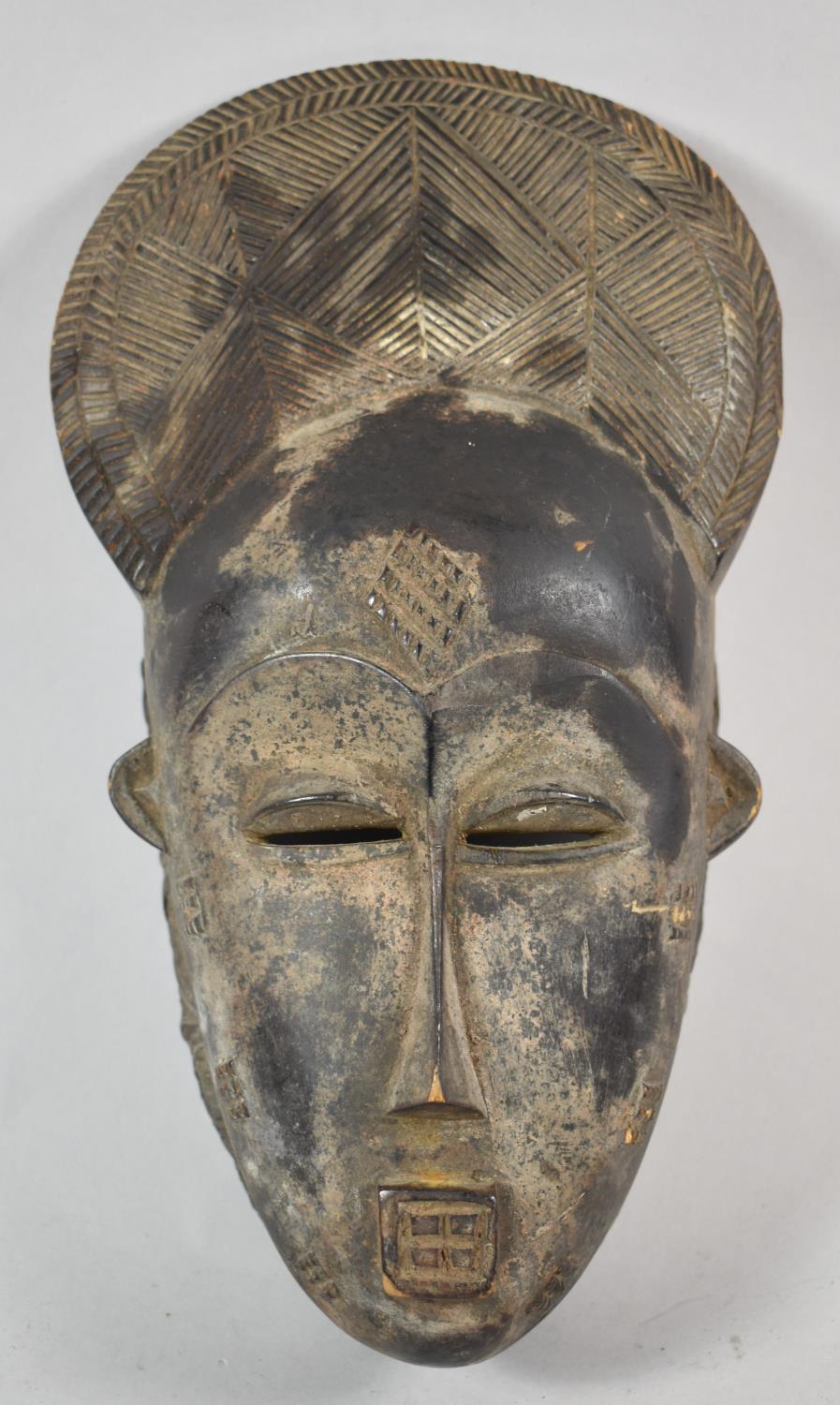 A West African Carved Tribal Mask, Ivory Coast, 34cm high