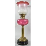 A Late Victorian Oil Lamp with Cranberry Glass Reservoir and Opaque Etched Shade, the Stand in the