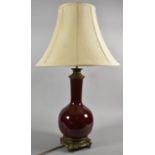 A Sang Boeuf Glazed Vase Shaped Table Lamp with Ormolu Mounts and Stand Having Dolphin Supports,