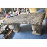 A Reconstituted Stone Crescent Shaped Garden Seat on Elephant Supports, 108cm wide
